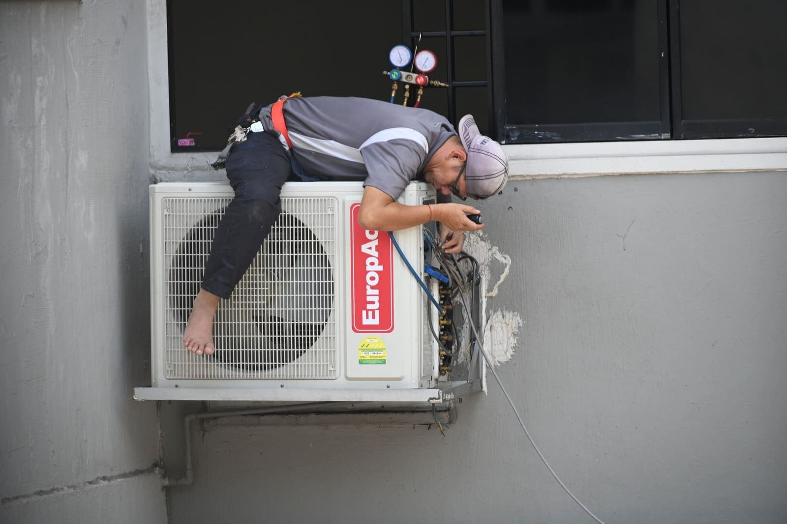 HVAC technician servicing air conditioning plant equipment